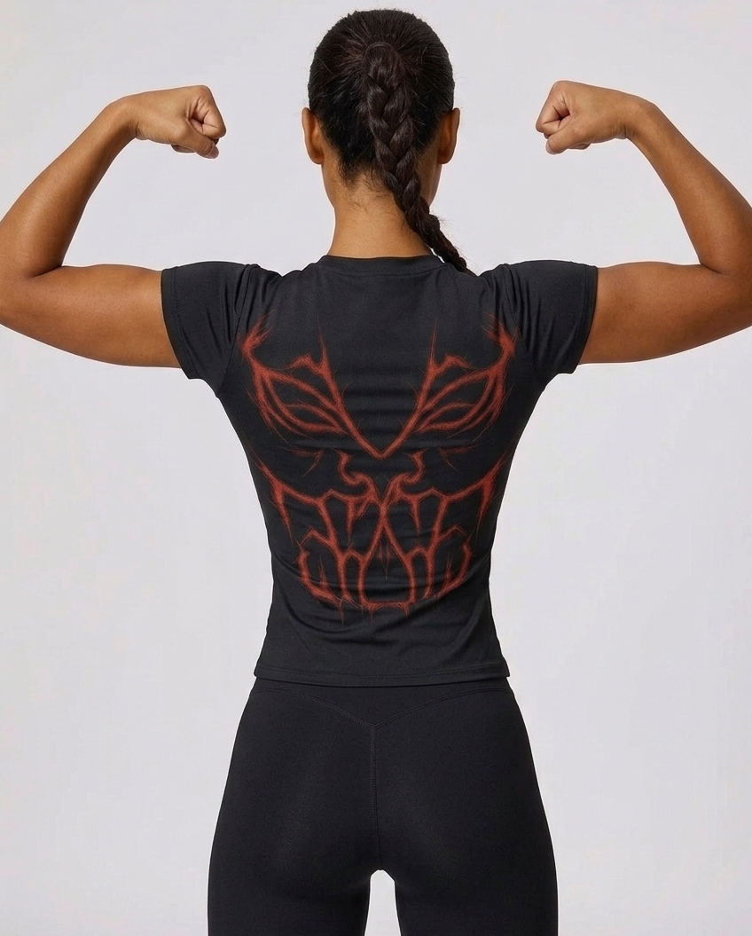 Person wearing a black t-shirt with red tribal design on the back, flexing muscles against a light gray background.