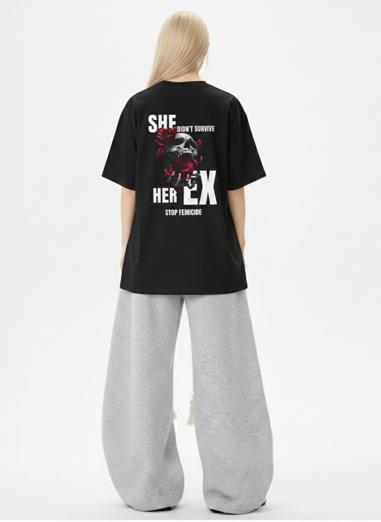 Person wearing a black t-shirt with graphic design and text on the back, standing against a white background.