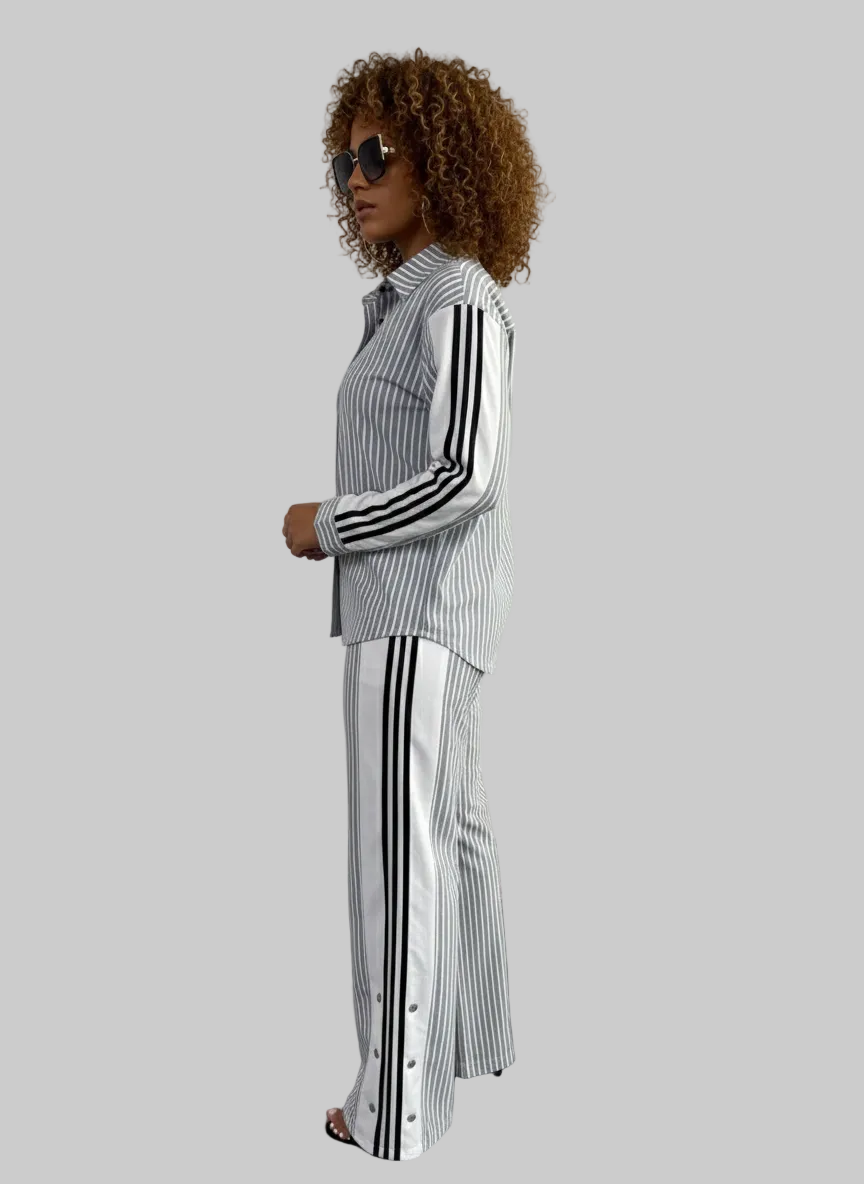 Woman wearing a black and white striped outfit in a minimal indoor setting