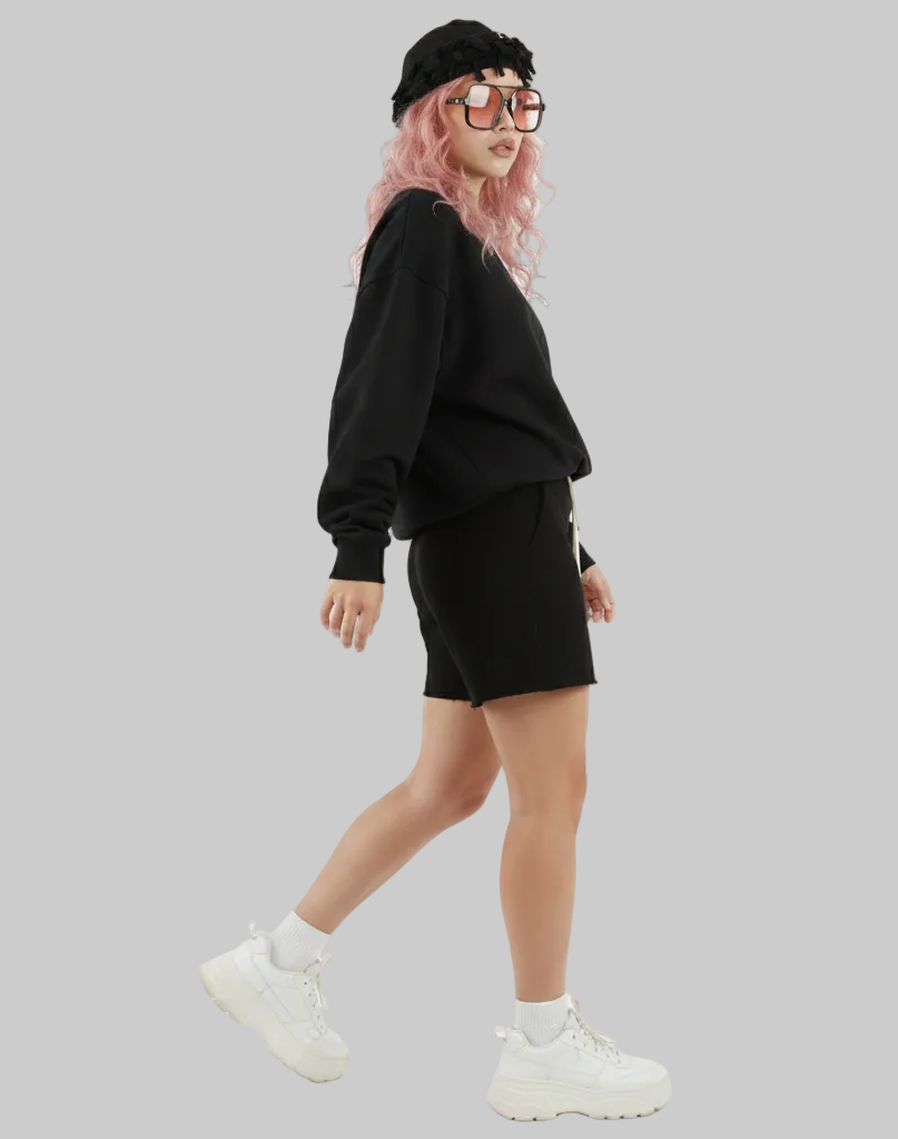 Person wearing a black outfit with shorts on a white background