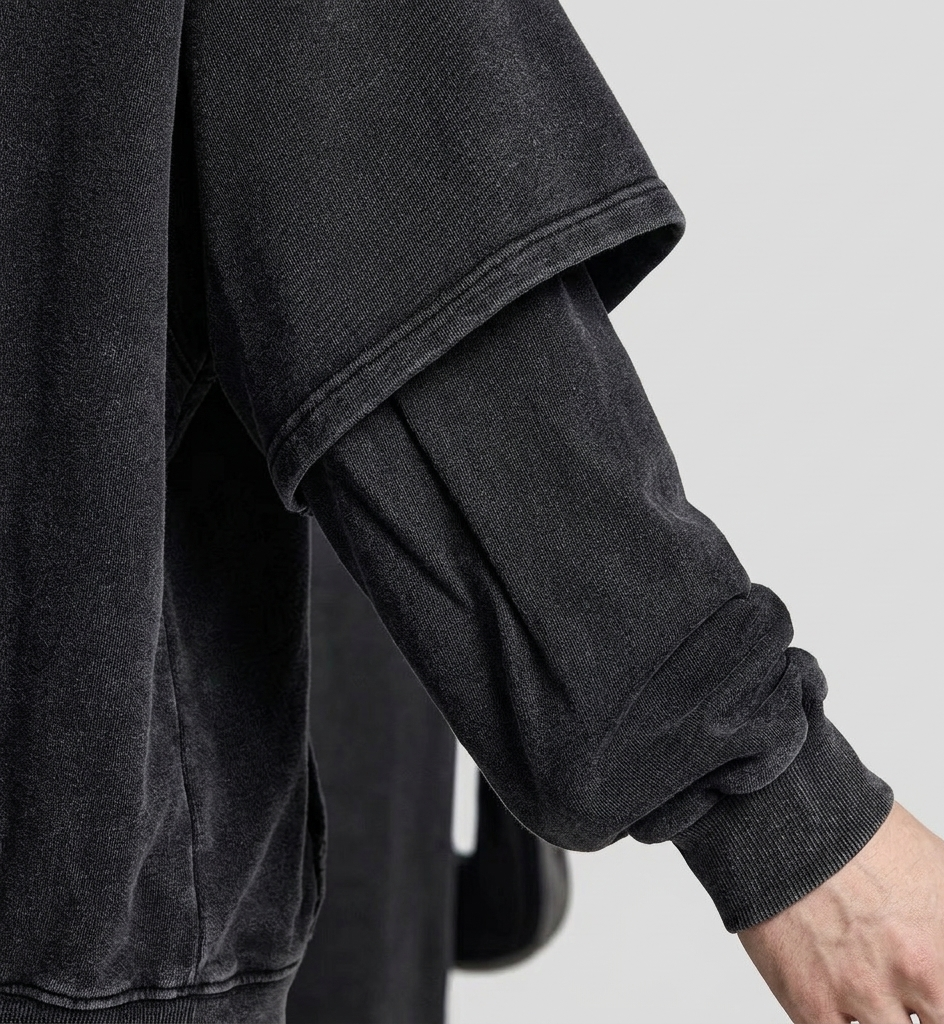 Close-up of a dark gray sweatshirt with a blurred background