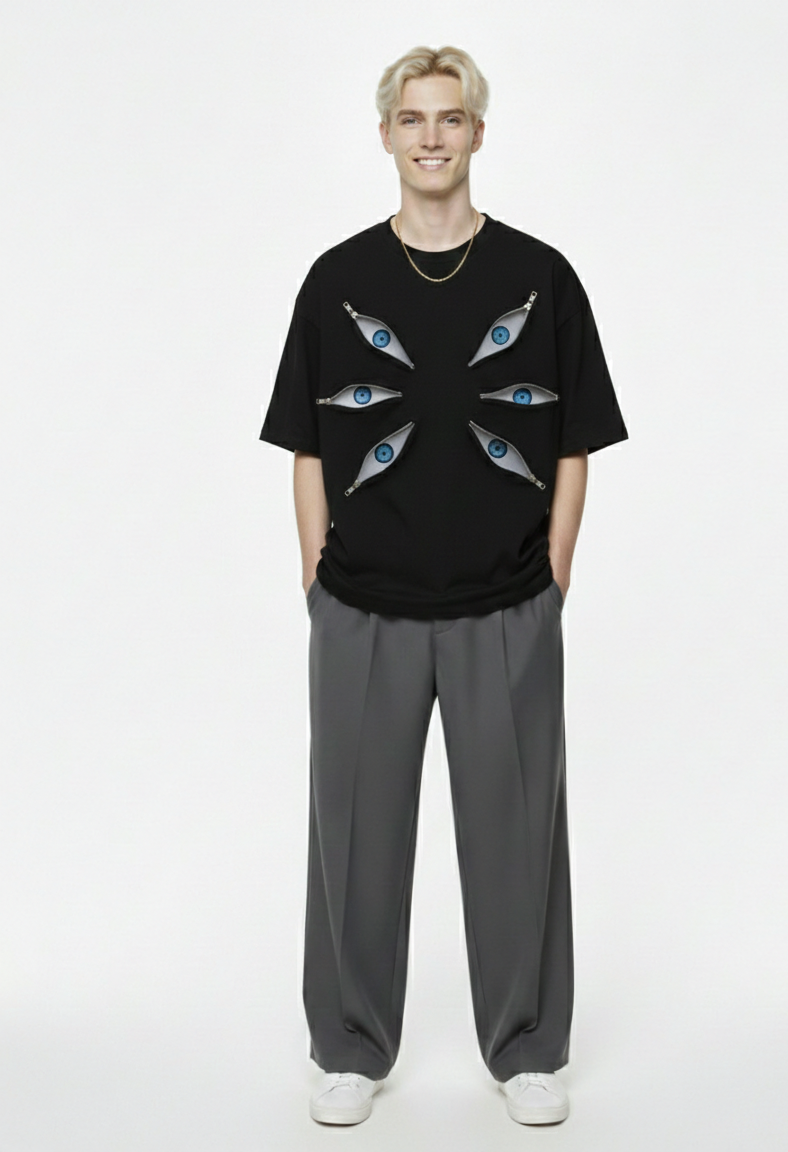 Person wearing a black t-shirt with graphic design and gray pants on a white background
