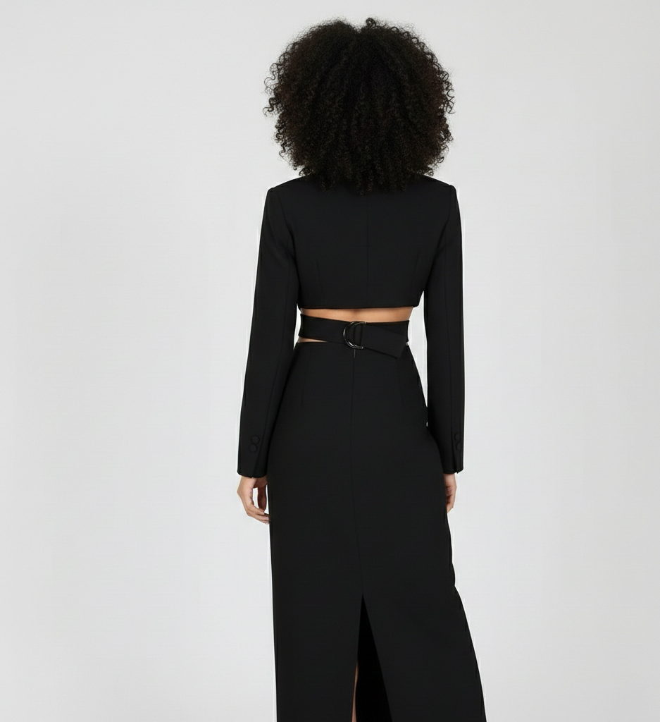 Person wearing a black long-sleeve top and high-waisted pants on a light gray background