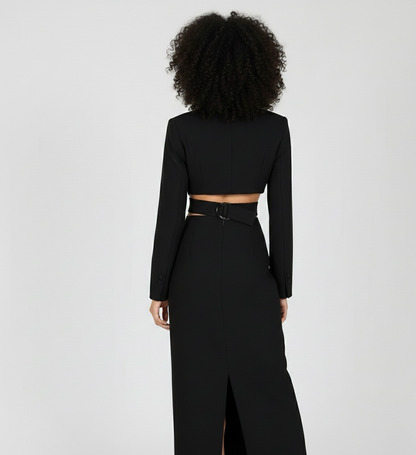 Person wearing a black long-sleeve top and high-waisted pants on a light gray background