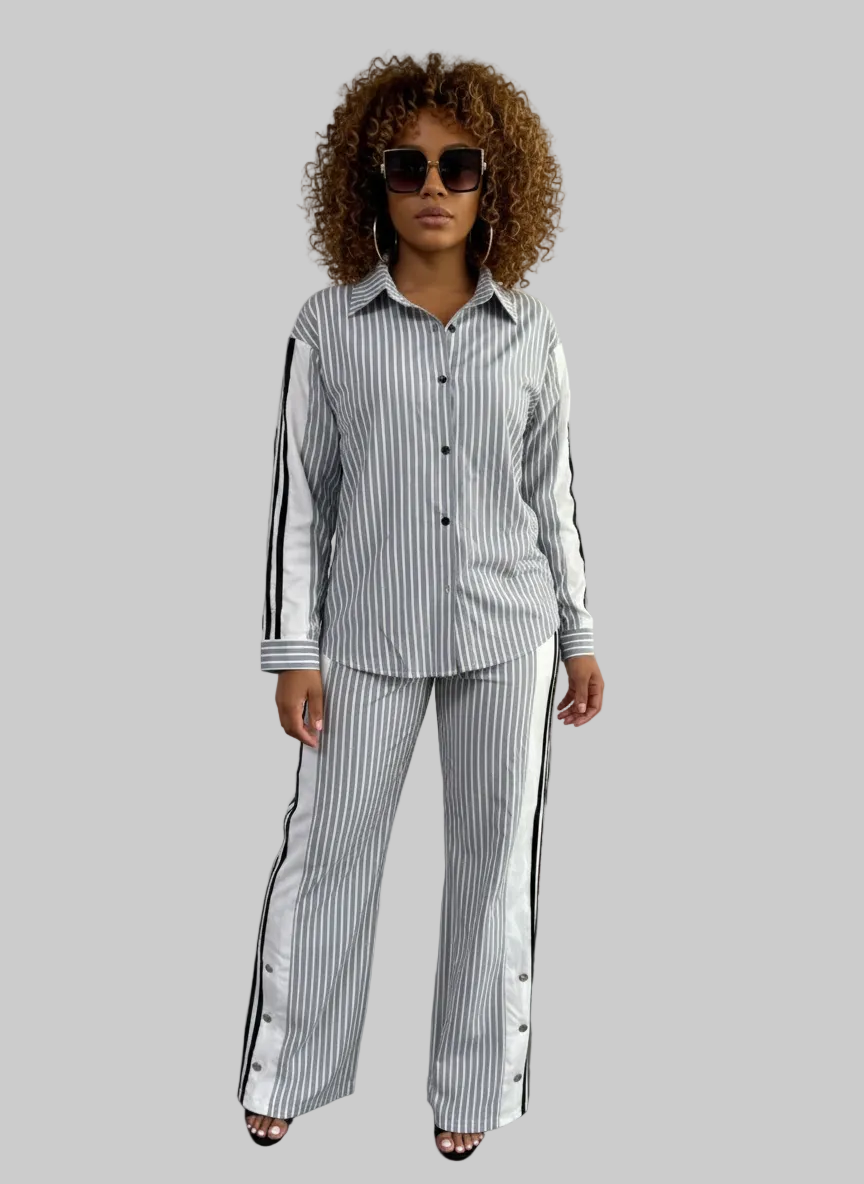 Woman wearing a striped outfit with black sunglasses in a minimal indoor setting