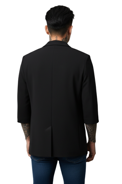 Person wearing a black blazer from behind on a plain background