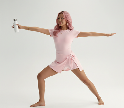 Woman in a pink outfit posing with a white water bottle on a white background