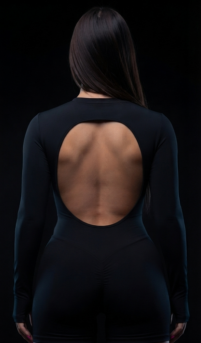 A woman shown from the back wearing a black long-sleeve bodysuit with a large open-back cutout, photographed against a black background.