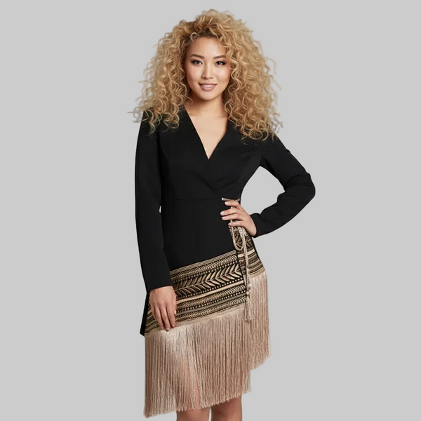 Woman wearing a black top and beige fringe skirt on a gray background