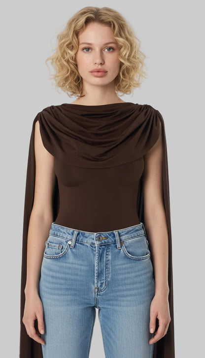 Woman wearing a brown draped top and blue jeans on a white background