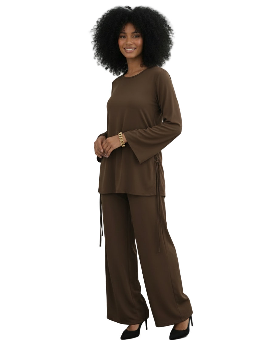 Woman wearing a brown outfit against a white wall