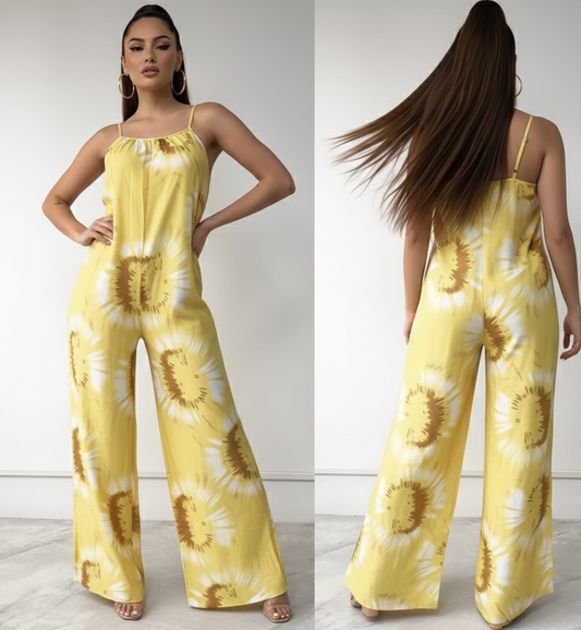 Woman wearing a yellow tie-dye jumpsuit with a plain background
