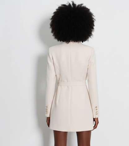 Person wearing a cream blazer on a plain background