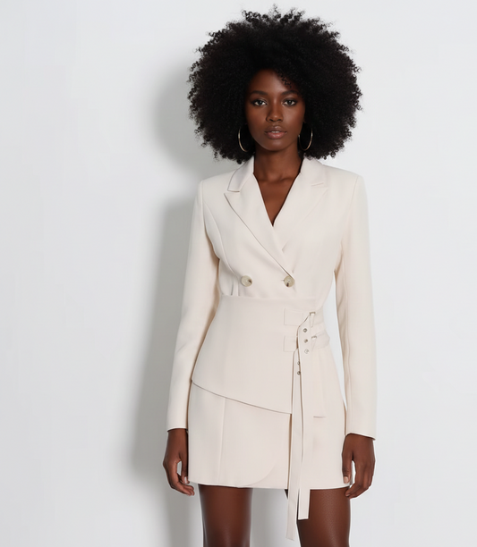 Woman wearing a cream-colored blazer dress against a white background