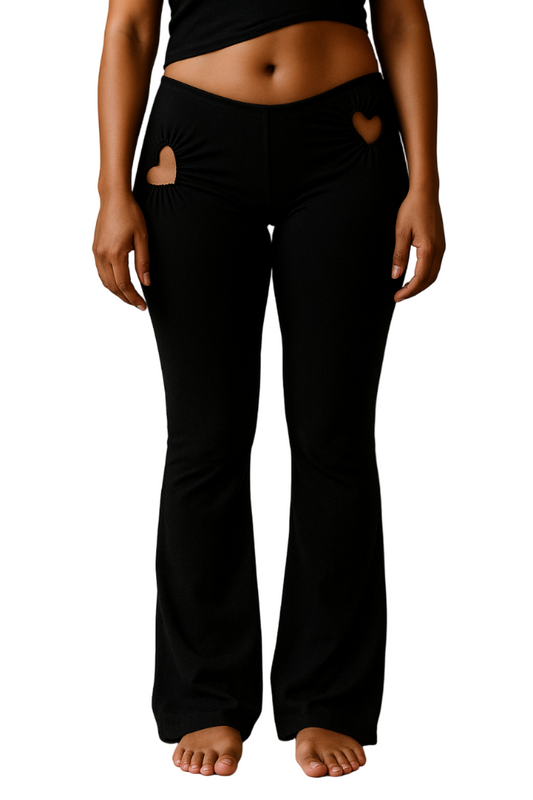 Person wearing black pants with heart designs on a white background