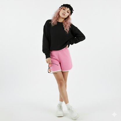 Person wearing a black sweatshirt and pink shorts on a white background